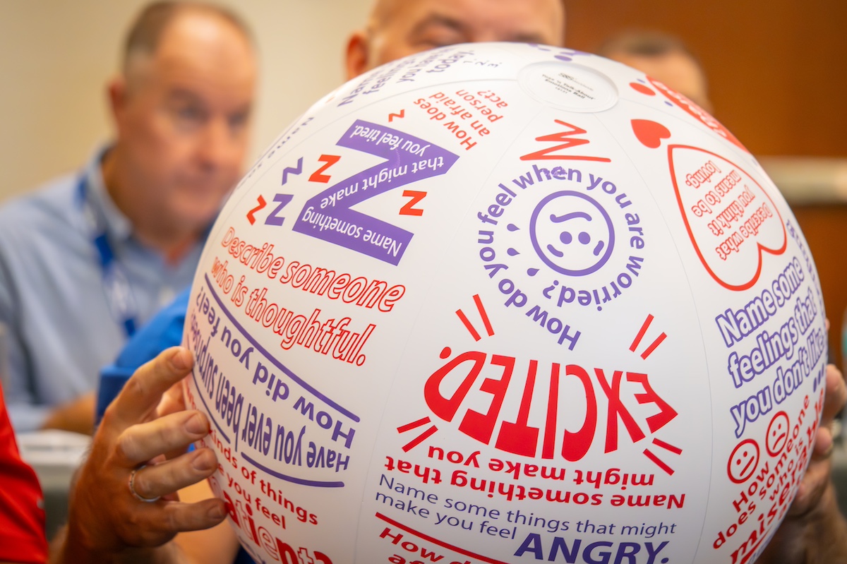 Person holding a ball with phrases on it during a team building excercise