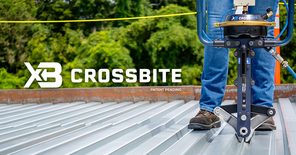 Person using Crossbite side lap connection tool on a steel roof top