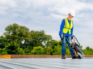 Person using Crossbite side lap connection tool on a steel roof top