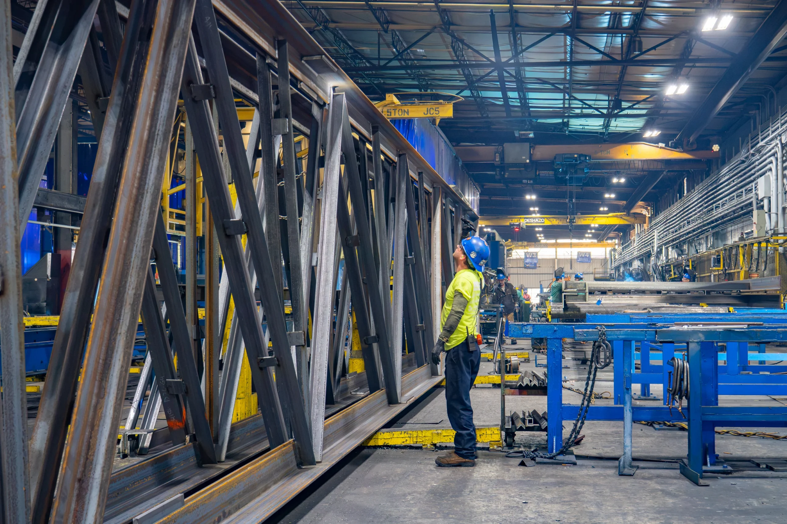 man with a lanyard speaking to an employee